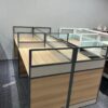 4-way brown office workstation with individual glass partitions and built-in drawer units for efficient workspace organization.