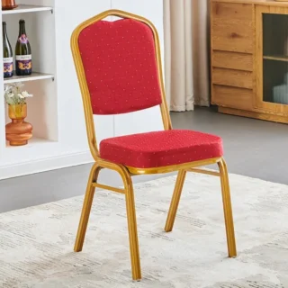 Conference or banquet chair with red fabric upholstery and a golden metallic frame in an elegant indoor setting.