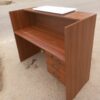 1400mm Office Reception Desk with wood finish, raised counter, and lockable drawers.