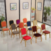 Conference or banquet chair with red fabric upholstery and a golden metallic frame in an elegant indoor setting.